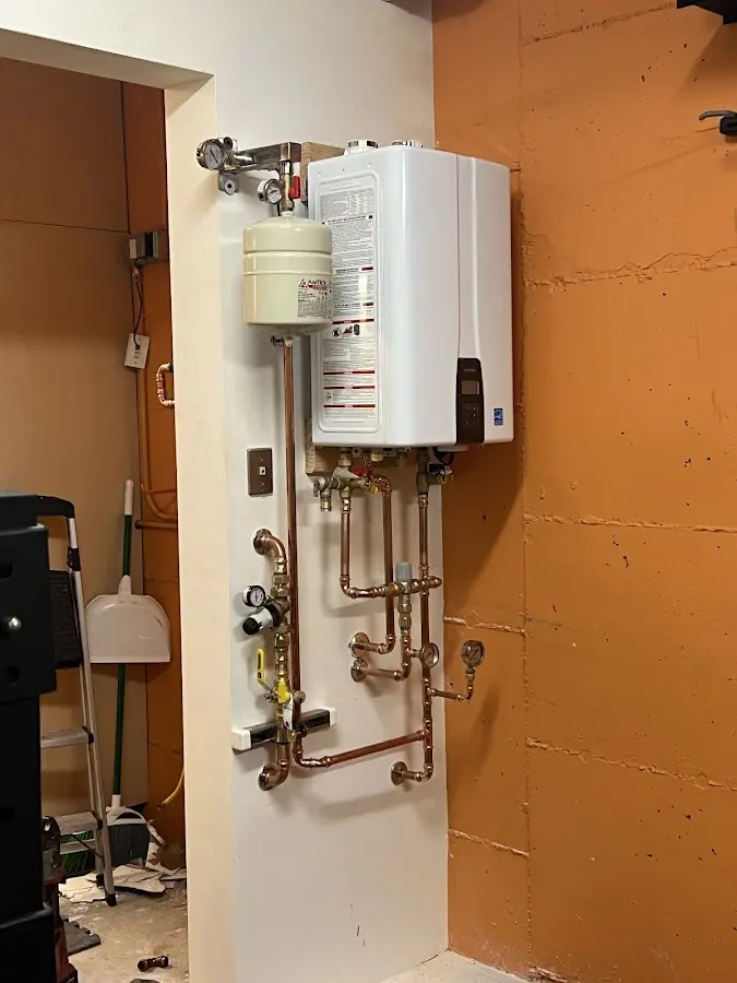 Plumbing technician inspecting water heater connections in Sugarloaf